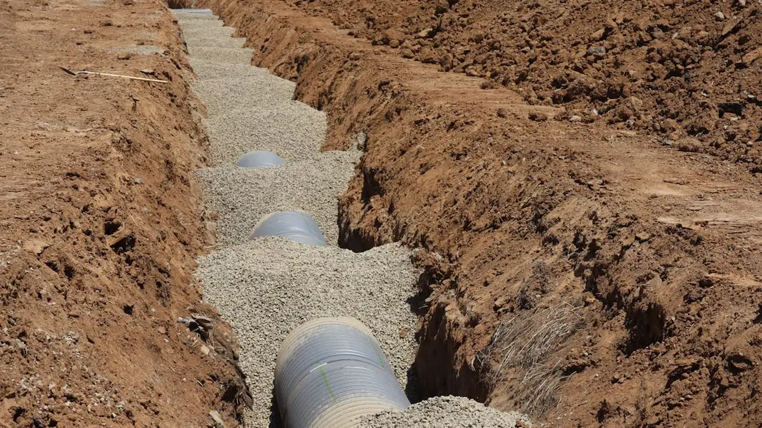 Tranchée drainante périphérique avec drain et graviers le long d'un mur enterré - Arcey Construction