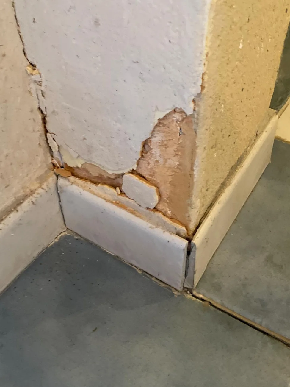 Angle de mur intérieur dont l'enduit se décolle et cloque, avant remise en état