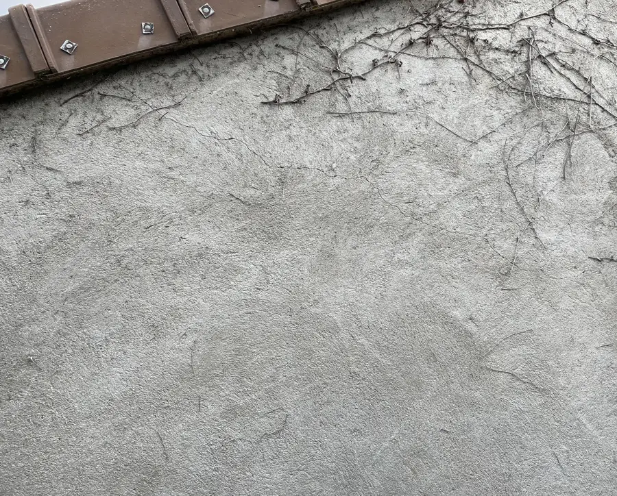 Faïençage d'un enduit de façade, réseau de fissures fines en surface