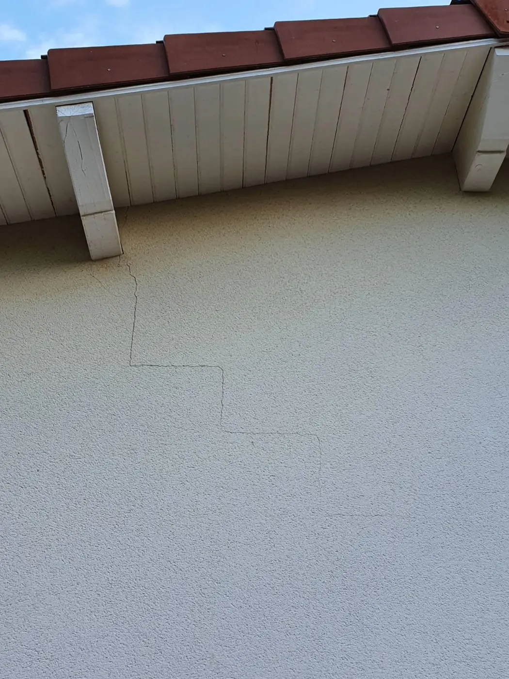 Fissure en escalier sur une façade enduite, sinistre fissures déclaré à l'assurance