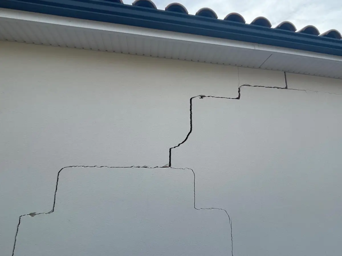 Fissure en escalier sur une façade, dommage structurel couvert par la garantie décennale