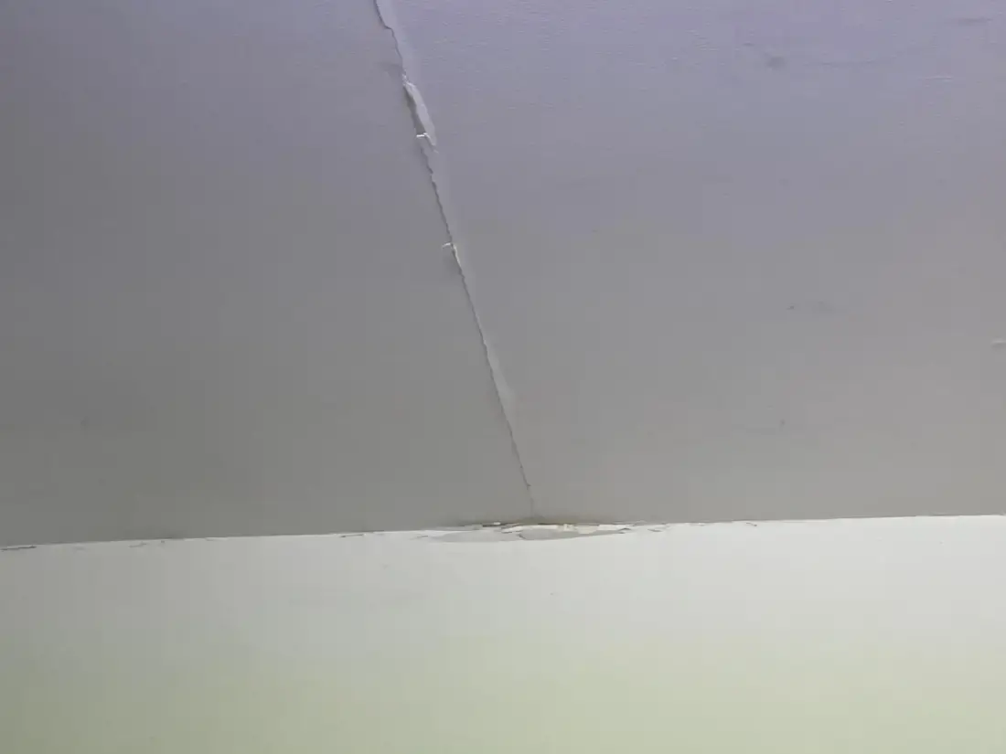 Fissure fine au plafond avec léger écaillage, cas typique traité par calicotage