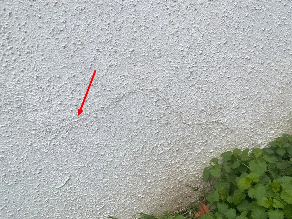 Fissure horizontale annotée sur un mur lors d'une expertise