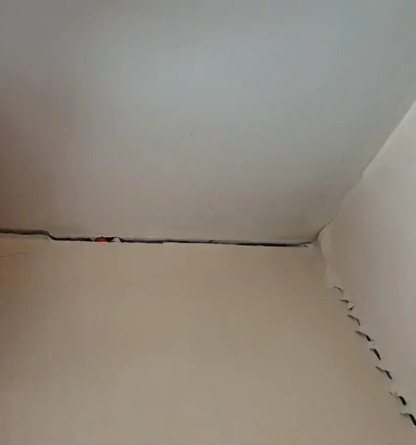 Fissure au raccord entre un mur et le plafond, désordre à signaler après réception