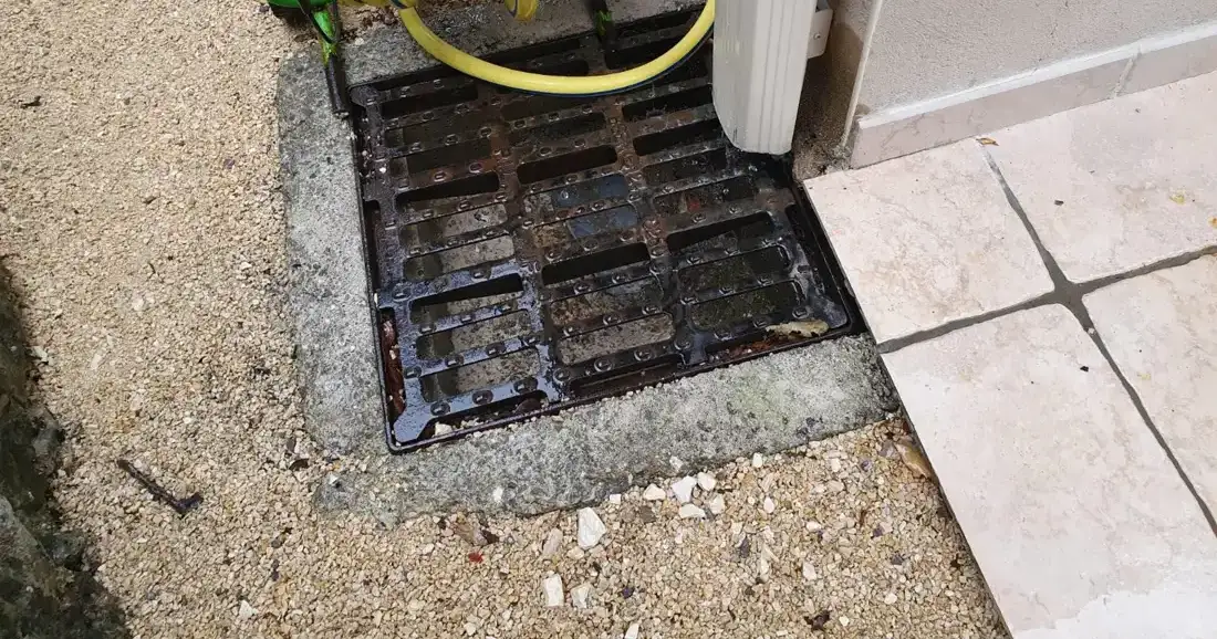 Grille d'évacuation des eaux pluviales en pied de façade