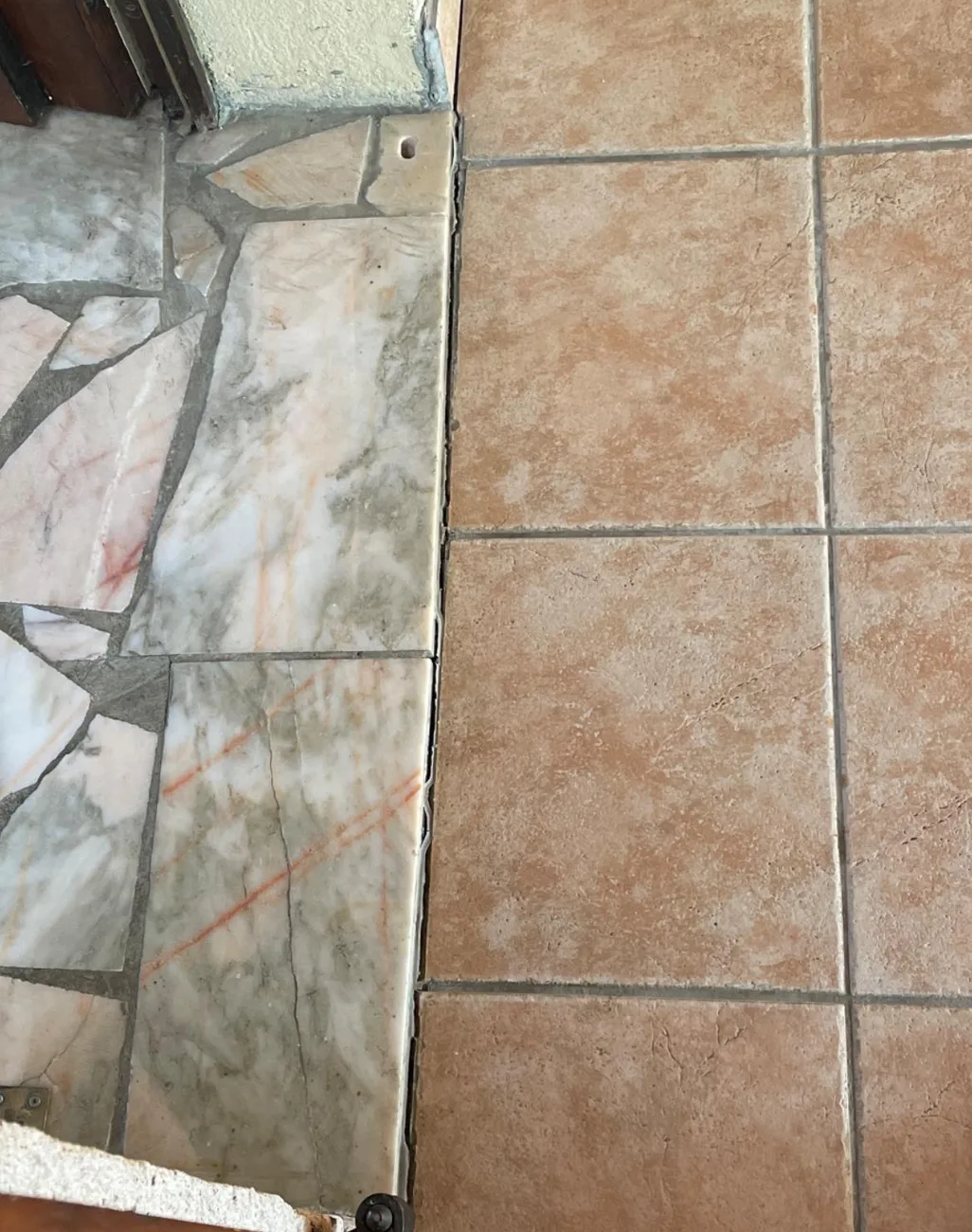 Raccord entre un ancien sol en marbre et un carrelage neuf posé lors d'une reprise