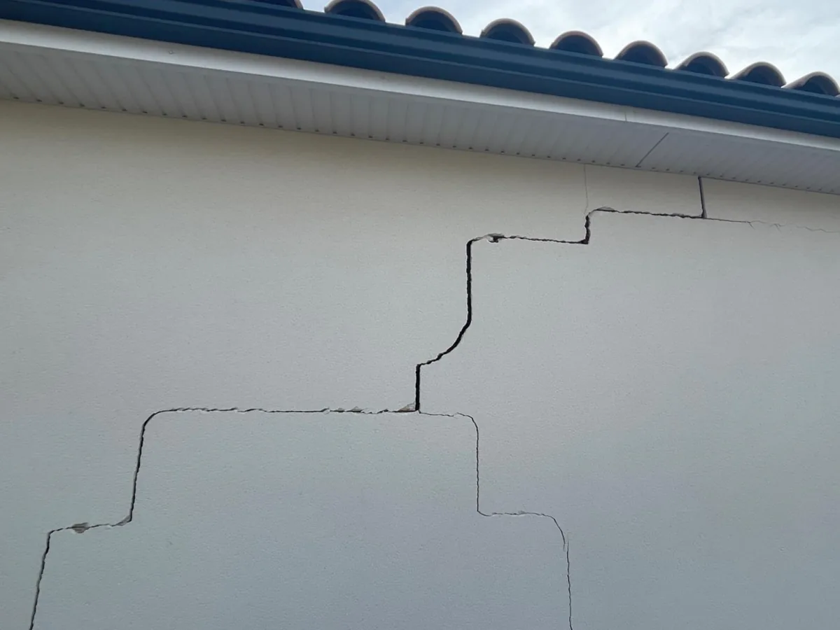 Fissure en escalier sur façade de maison